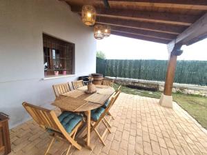 a wooden table and chairs on a patio at La Cochera del Abuelo in Medina de Pomar +6 photos