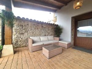 a patio with a couch and a table and a door at La Cochera del Abuelo in Medina de Pomar