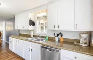 a kitchen with white cabinets and a sink at Eternal Sunrises in Sunrise Beach