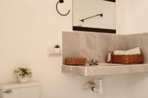 a bathroom with a sink and a shelf above a toilet at Casa Bedz, alberca privada in Campeche +18 photos