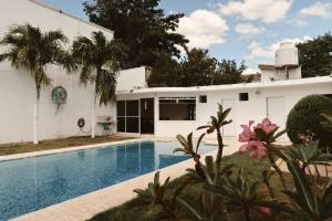 a white house with a swimming pool in front of it at Casa Bedz, alberca privada in Campeche