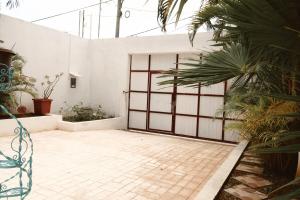 a garage door in a white building with plants at Casa Bedz, alberca privada in Campeche
