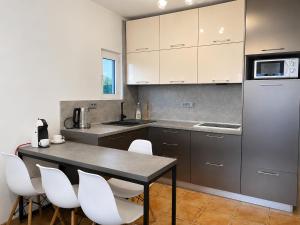 a kitchen with a table and some white chairs at Comfort Apartment Becici in Bečići