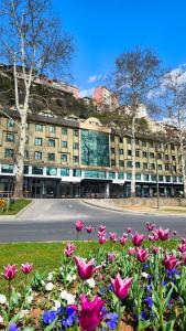 a large building with pink flowers in front of it at Türkler Suite Hotel in Trabzon