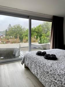 a bedroom with a bed and a large window at Duplex appartement in rustige woonwijk in Mortsel