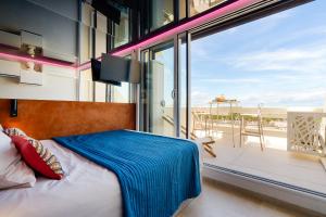 a bedroom with a bed and a balcony with a view at Cap Cosy studio standing Naturiste Heliopolis Cap d'Agde with Sea View in Cap d'Agde +18 photos