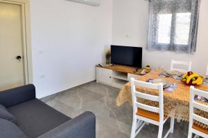 a living room with a table and a tv at Stegna Holiday 2 in Archangelos