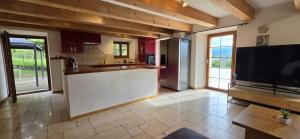 a kitchen with a large television and a kitchen island at La Rochetta in Chatel sur Montsalvens