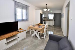 a living room with a dining table and a television at Stegna Holiday 2 in Archangelos