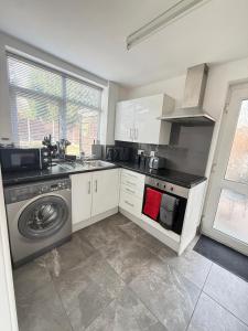 a kitchen with a sink and a washing machine at Families and Contractors Dudley DY1 in Lower Gornal