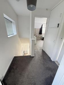 a hallway of a house with white walls and carpet at Families and Contractors Dudley DY1 in Lower Gornal