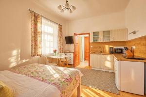 a bedroom with a bed and a kitchen with a table at Villa Harmony in Český Krumlov +39 photos