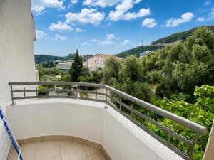 a balcony with a view of trees and mountains at Comfort Apartment Becici in Bečići
