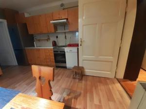 a kitchen with wooden cabinets and a door and a table at Let's go back to the memories in Krakow