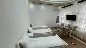 a hospital room with two beds and a television at Daniel SAMARKAND in Samarkand