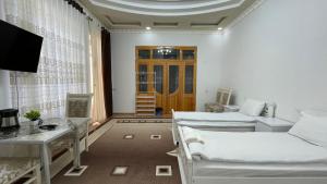 a living room with two beds and a door at Daniel SAMARKAND in Samarkand