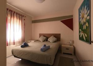 a bedroom with a bed with two blue pillows on it at Pool View & Terrace Apartments in Corralejo +16 photos