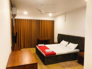 a bedroom with a bed with a red blanket at REEF VIEW Beach Hotel in Matara