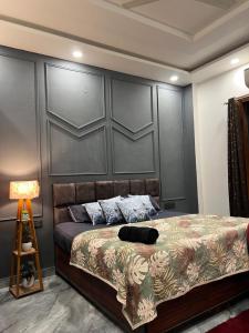 a bedroom with a bed with a large gray headboard at Starlight villa in Ghaziabad