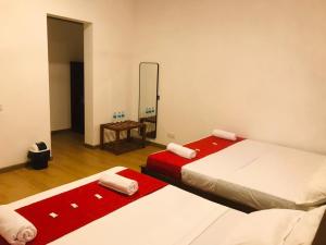 two beds in a room with a mirror at REEF VIEW Beach Hotel in Matara +14 photos