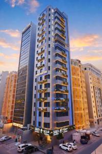 a tall building with cars parked in front of it at Saray Prime Suites in Kuwait