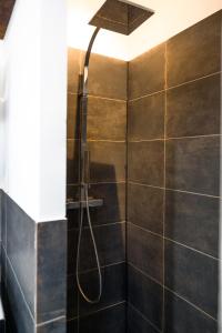 a shower with a shower head in a bathroom at Le Grand Rue Signature - Appartement coeur de ville, rue piétonne in Bergerac +40 photos