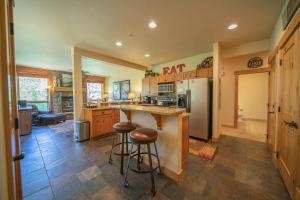a kitchen with a counter and stools in it at Settlers Creek 6514 by SummitCove Lodging in Colorado in Keystone