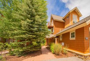 a house with a pine tree next to a driveway at Settlers Creek 6514 by SummitCove Lodging in Colorado in Keystone