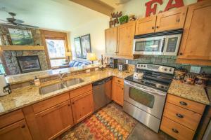 a kitchen with wooden cabinets and stainless steel appliances at Settlers Creek 6514 by SummitCove Lodging in Colorado in Keystone