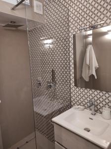 a bathroom with a sink and a shower with a mirror at Corollario 21 in Barletta