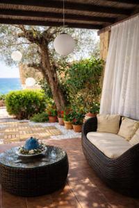 a wicker couch sitting on a patio with a table at Magic Mola in Mola Kalyva