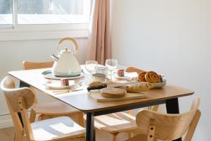a table with a tea kettle and bread on it at Le Grand Rue Signature - Appartement coeur de ville, rue piétonne in Bergerac