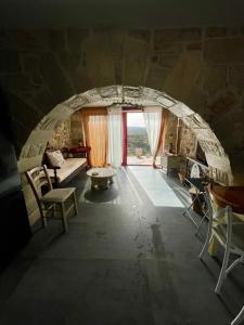 an archway in a room with a couch and chairs at Ahiri traditional cottage in Galatás