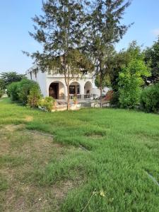 a house with a large yard with grass at Green Haven Farm & Events in Bhundsi
