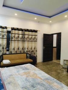 a bedroom with a bed and a couch and curtains at Green Haven Farm & Events in Bhundsi