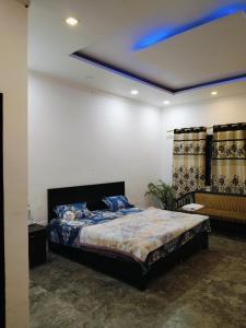 a bedroom with a bed and a blue ceiling at Green Haven Farm & Events in Bhundsi +12 photos