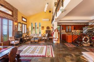 a large living room with yellow walls and a staircase at Heritage Ridge in Skroponeria +42 photos