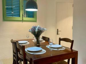 a dining room table with chairs and a vase of flowers at Apt Es Poal - Des Puig in Cadaqués