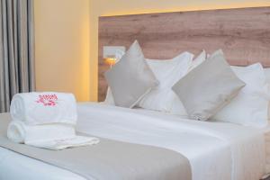 a white bed with pillows and towels on it at Amanda Resort in Kakamega +39 photos