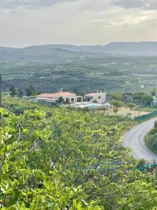 a road leading to a white building on a hill at Ahiri traditional cottage in Galatás