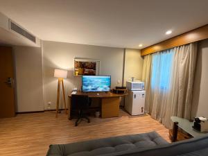 a living room with a desk with a computer in it at Hotel Wynd Ibirapuera 512A in São Paulo