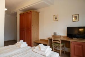 a bedroom with two beds and a desk and a television at Hotel al Dòs - Breakfast & Private SPA in Trento