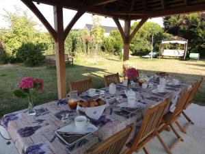 a table set for a meal under a gazebo at Le Clos des Bérengeries in Saint-Patrice