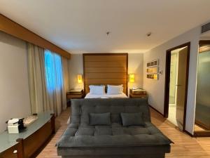 a hotel room with a bed and a couch at Hotel Wynd Ibirapuera 512A in São Paulo