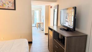 a bedroom with a flat screen tv on a dresser at Atlantic Crest Inn and Suites in Myrtle Beach