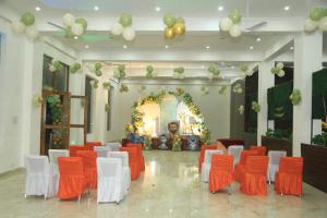 a room with orange and white chairs and a altar at Foreste Resort in Rāmnagar +29 photos
