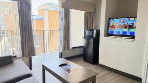 a living room with a couch and a flat screen tv at Atlantic Crest Inn and Suites in Myrtle Beach +12 photos