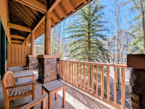 a porch of a cabin with a bench and a fireplace at Arapahoe Lodge 8105 by SummitCove Lodging in Colorado in Keystone
