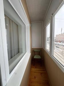 a empty hallway with a chair and a window at Central Comfort in Konotop