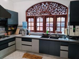 a kitchen with a sink and a large window at D & N Homes- Villa 1 in Kalutara